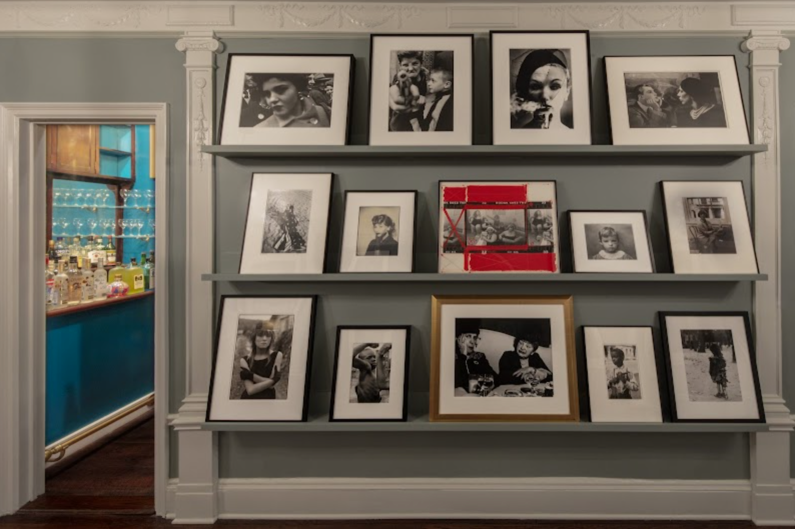 Interior of Alice Sachs Zimet's home; 3 rows of shelves showcasing photographs